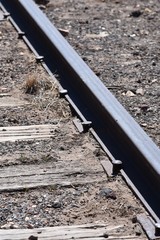 Spikes hammered into railroad ties holding down the track