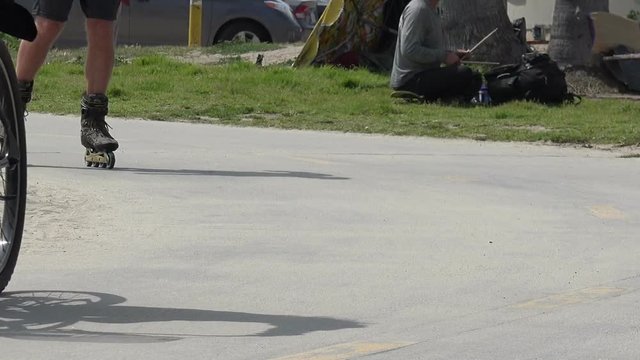 Bikes, skateboards and rollerblades going past on the beach bike path