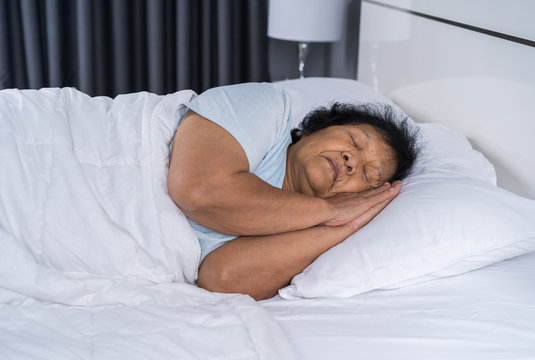 Old Woman Sleeping On A Bed