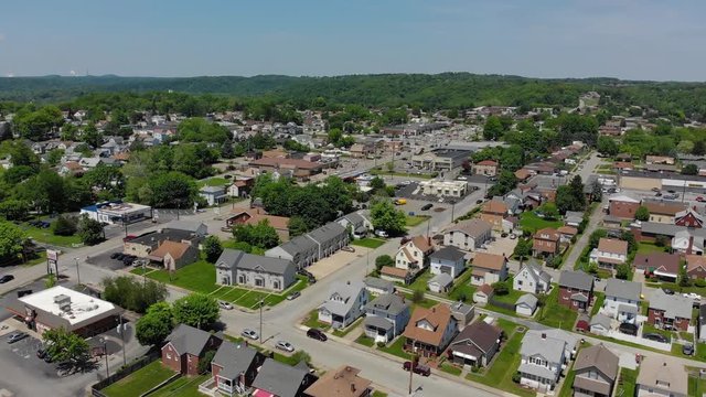 A slowly moving forward aerial establishing shot of a Pennsylvania small town's business and residential districts. Pittsburgh suburbs.  	