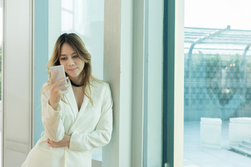 Fototapeta premium Beautiful women use the phone at the window.