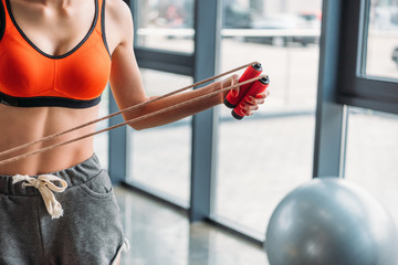 cropped shot of sportswoman holding jump rope at gym - obrazy, fototapety, plakaty
