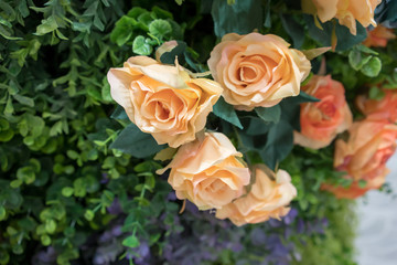 Closed up artificial orange and yellow rose flower made from silk. Real touch artificial flower for decoration.