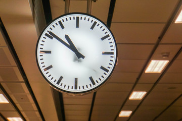 big hanging analog clock at underground train station