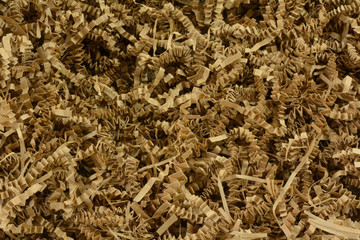 Close up of crinkled shredded brown paper box filler for shipping fragile items to prevent damage and breakage