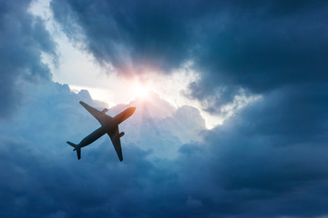 Naklejka premium Airplane in dark blue sky and cloud in sunrise