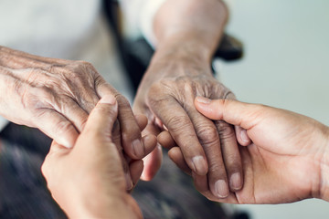 Nahaufnahme der Hände von helfenden Händen älterer häuslicher Pflege. Mutter und Tochter. Konzept für psychische Gesundheit und Altenpflege