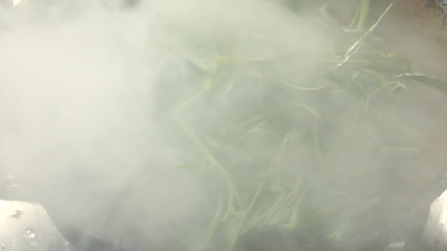 Frying  morning glory or Pad Pukbung  in pan Chiangmai  Thailand