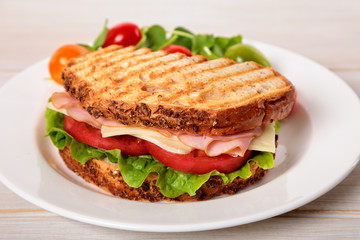 Toasted ham and cheese sandwich on wooden table