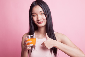 Young Asian woman thumbs up drink orange juice.