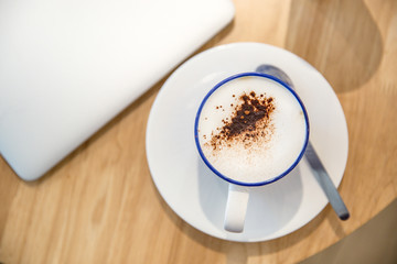 laptop with fresh cup of coffee, top view.