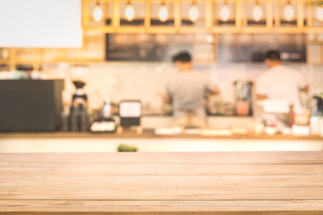 Wooden table and Blurred image of a barista dripping coffee on counter bar