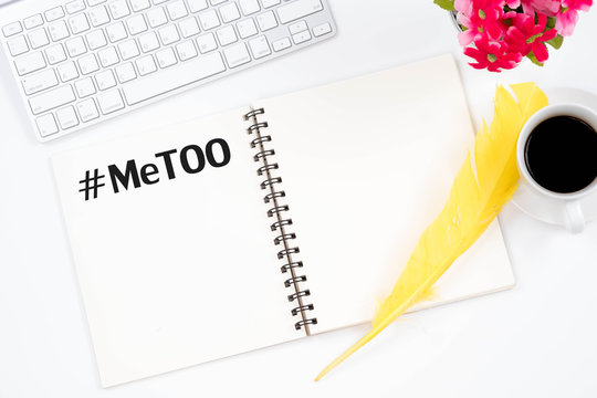 MeToo hashtag on note book and top viwe modern workplace on white background. Flat lay design. As part of anti sexual harassment and assault social media internet campaign protests