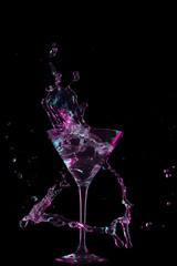 colorful cocktail in glass with splashes on dark background. Party club entertainment. Mixed light