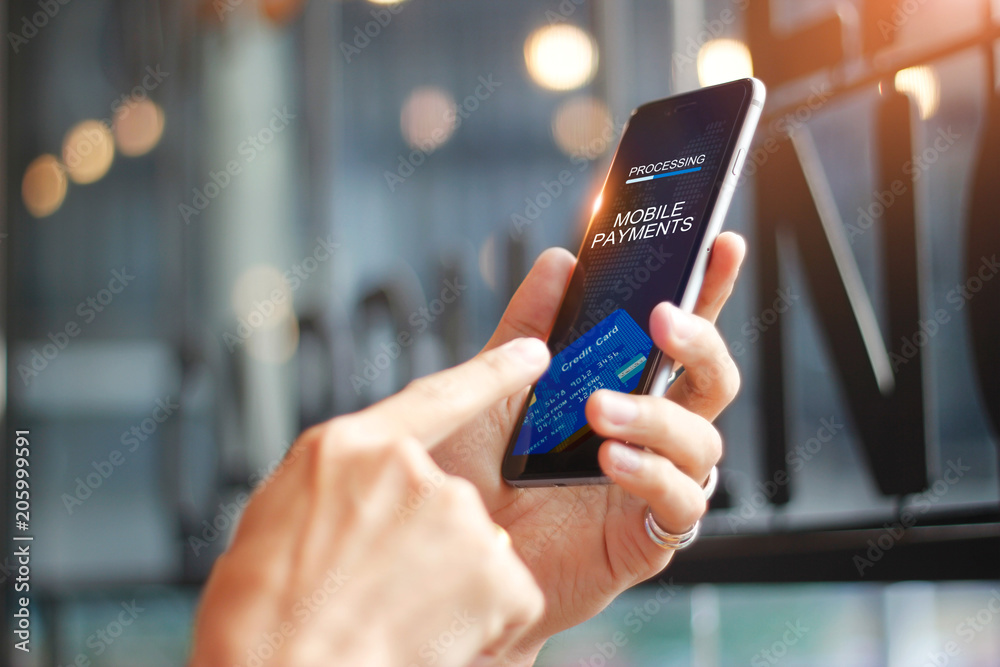 Aufkleber Man using mobile payments for online shopping network connection on screen, Coffee shop background. All on screen and credit card are designed up.