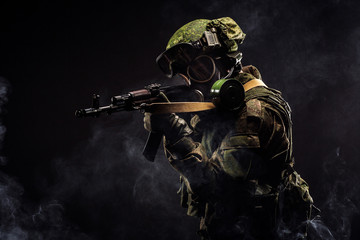 russian special forces soldier with rifle on dark background. army, military and people concept