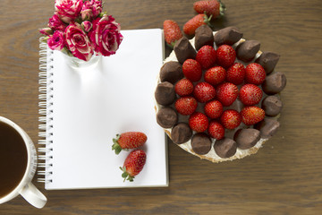Mockup with blank notepad, cup of coffee and cake. Small rose bouquet. Strawberry and chocolate frash bakery.
