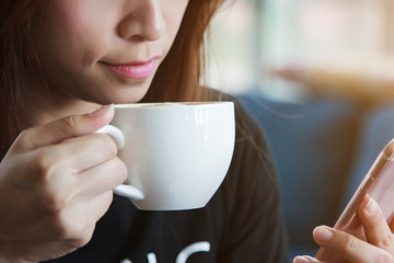 Women drink coffee and play smartphones.