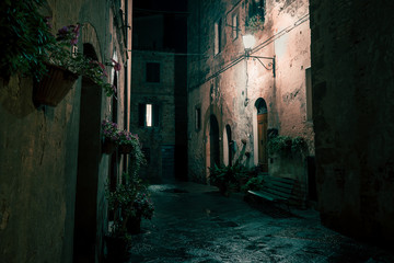 Old European narrow empty street of a medieval town at evening. Pienza, Italy