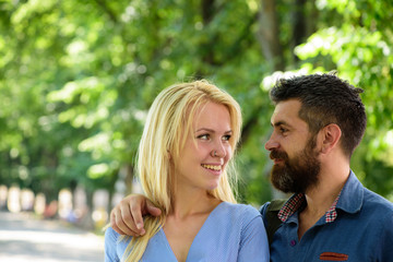 Man hugs happy blonde girlfriend, put hand on her shoulder.