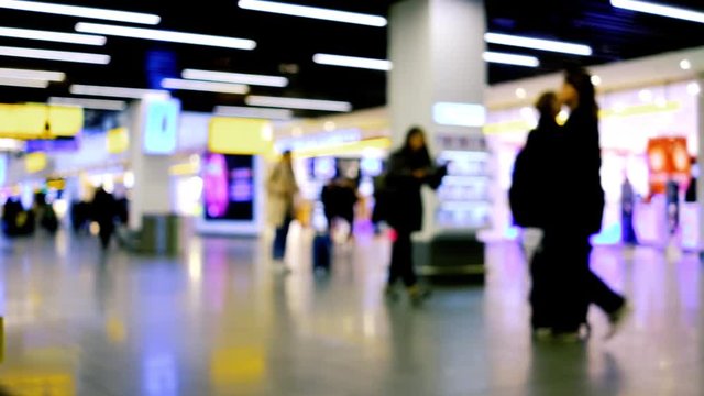 Crowd of people walking with luggage in the international airport, out of focus scene