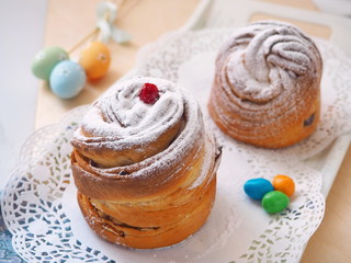 Obraz na płótnie Canvas Traditional Russian easter cake. Cruffin dessert, decorated with sugar powder, cranberries and easter eggs. Homemade treat. Selective focus.