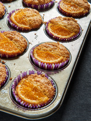 Home made orange muffins in a rustic baking tray
