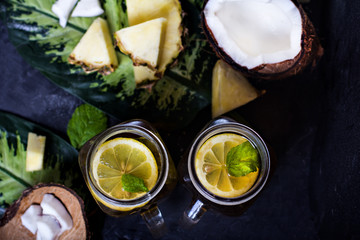 Summer drink, cocktail, tea, tropical fruits, pineapple, coconut, lime, summer background.