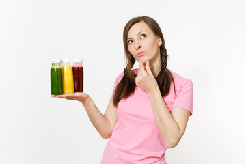 Fun woman holds row of green, red, yellow detox smoothies in bottles isolated on white background. Proper nutrition, vegetarian drink, healthy lifestyle, dieting concept. Copy space for advertisement.