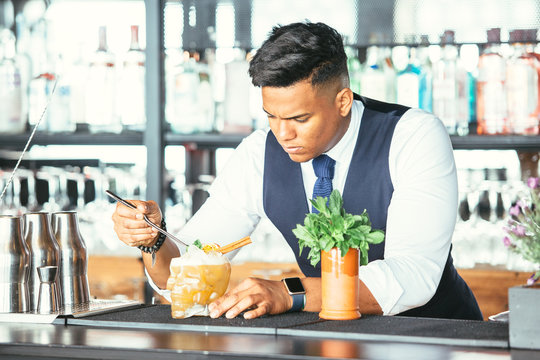 Expert barman decorates a cocktail
