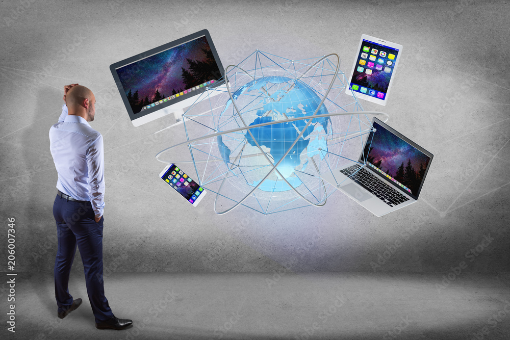 Poster businessman in front of a wall with a computer and devices displayed on a futuristic interface with 