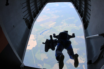 Skydivers are jumping out of a plane.