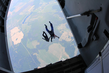 Skydivers are jumping out of a plane.