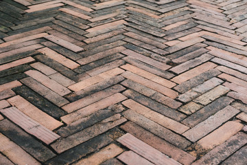 background of grunge red brick floor, arrow shaped pattern of old bricks on ground for decoration