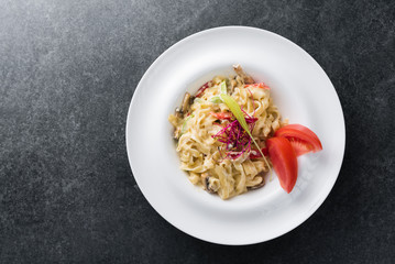 Italian paste of carbonaria with mushrooms with cream sauce on a white plate