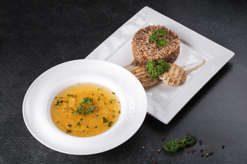 Complex dinner. Buckwheat porridge with dietary meat on a white plate is tenderly served