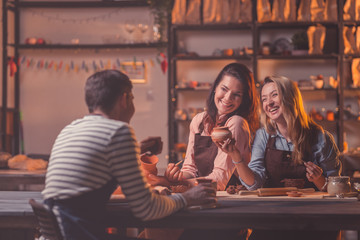 Smiling people at work in pottery