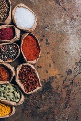 elevated view of colorful spices in paper bags on table