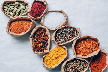 top view of colorful spices in paper bags on white table © LIGHTFIELD STUDIOS