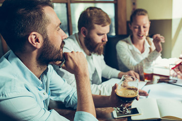 Obraz premium Young cheerful people smile and gesture while relaxing in pub.