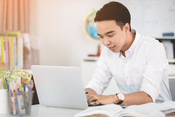 Happy young asian man at the office .