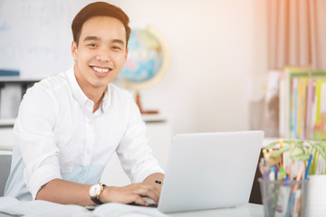 Happy young asian man at the office .