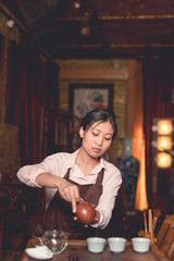 Young asian girl pouring tea