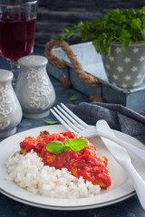 Flounder with tomato sauce and boiled rice, selective focus