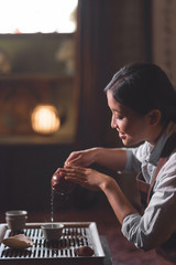 Young tea master pouring tea