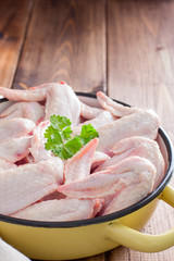 Raw chicken wings in an enamel frying pan, selective focus