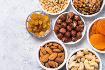 Nuts and dried fruits assortment on stone table top view.