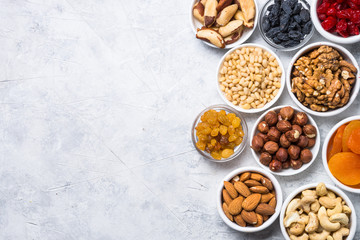 Nuts and dried fruits assortment on stone table top view. - obrazy, fototapety, plakaty