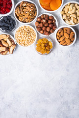 Nuts and dried fruits assortment on stone table top view.
