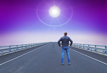 Man stands on a highway and looks on guiding star over horizon. Concept of wishes and romantic